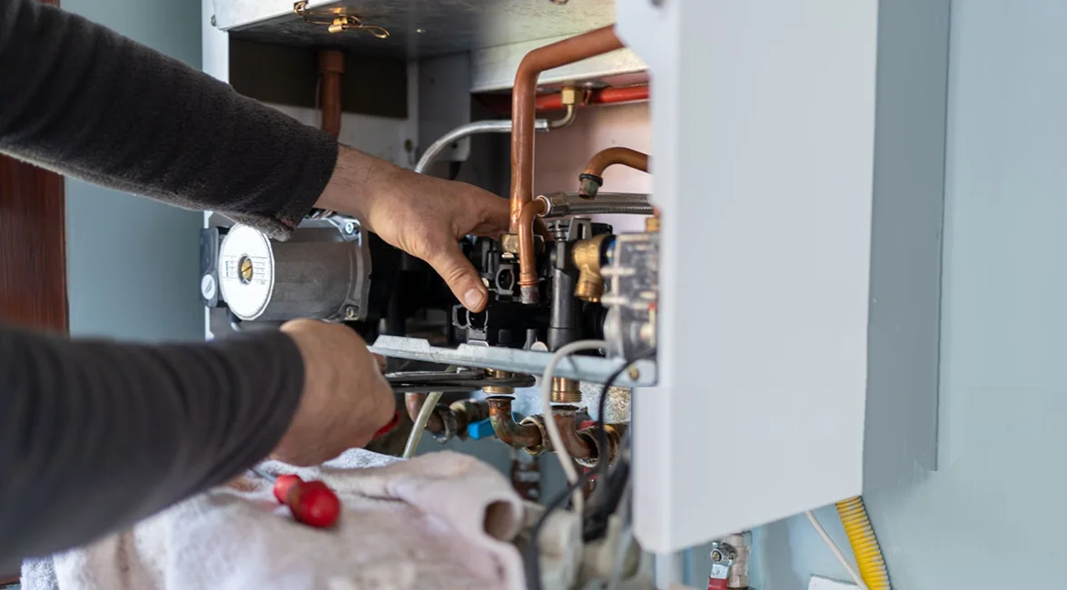 Heating service technician working on a heating system's internal components